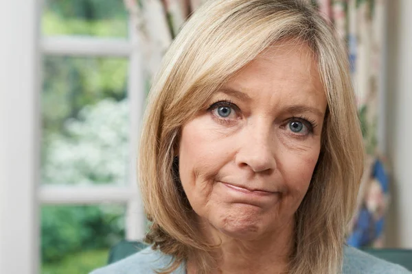 Middle-aged woman looking concerned with thephysical challenges of menopause, including weight gain.