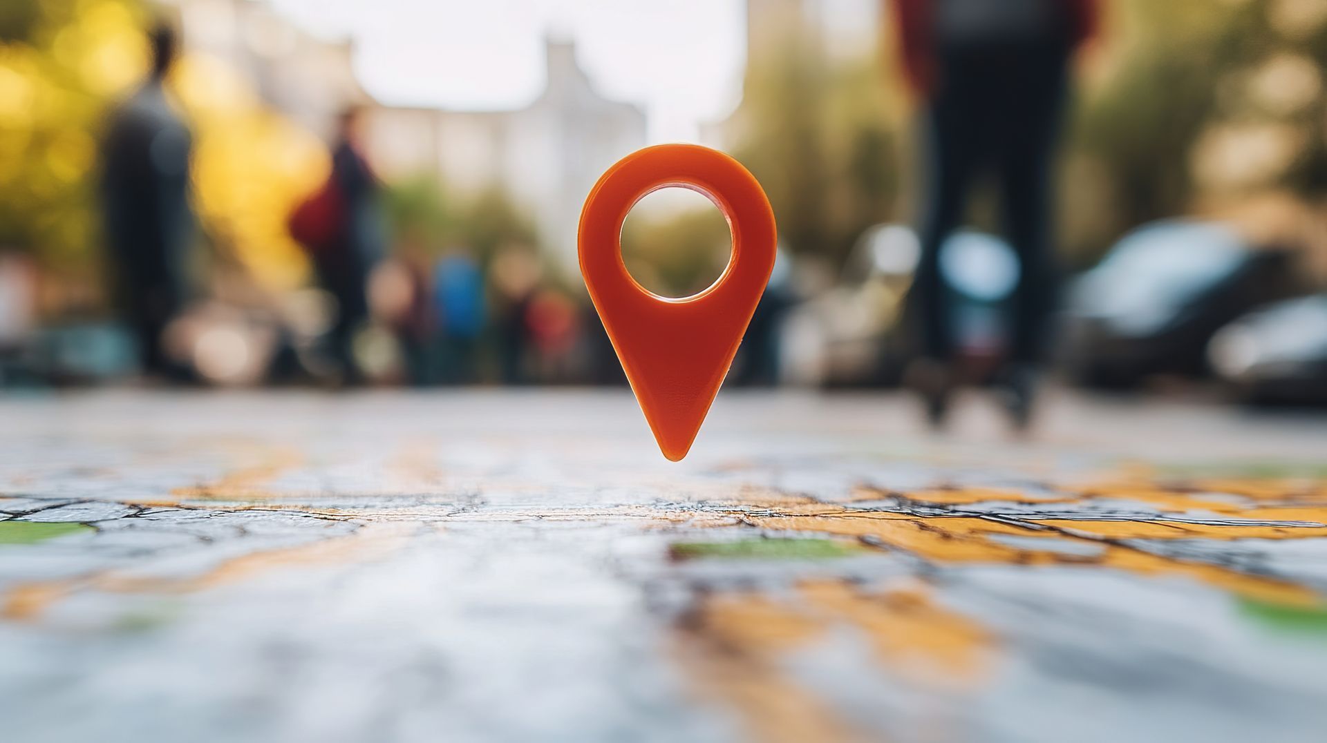 A red pin on a map with people walking in the background.