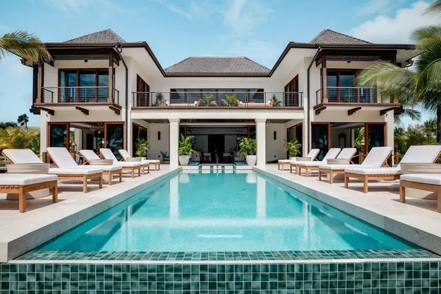 A large house with a large swimming pool in front of it