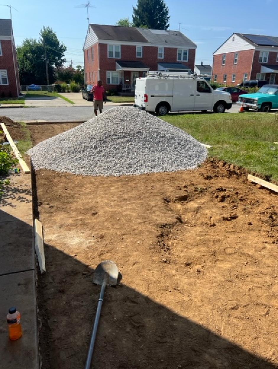 A pile of gravel is sitting in front of a white van