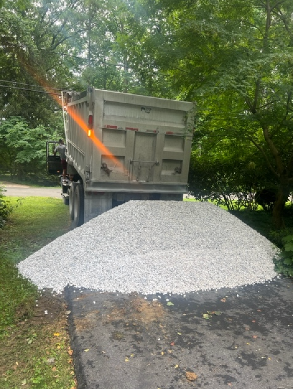 A dump truck is sitting on top of a pile of gravel.