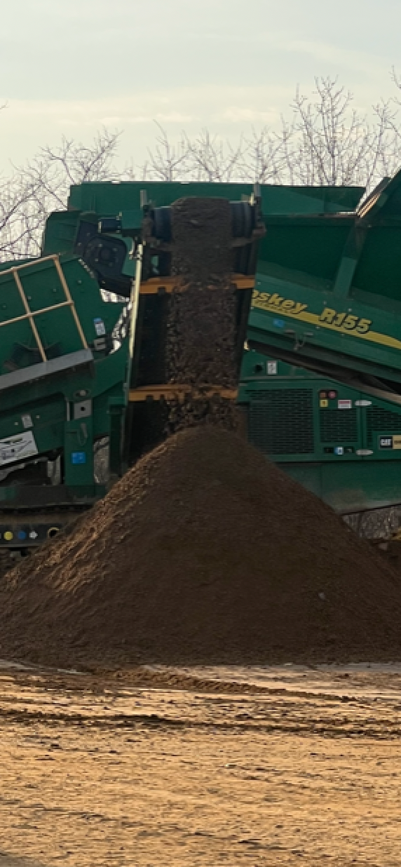 A pile of dirt is being loaded into a truck.