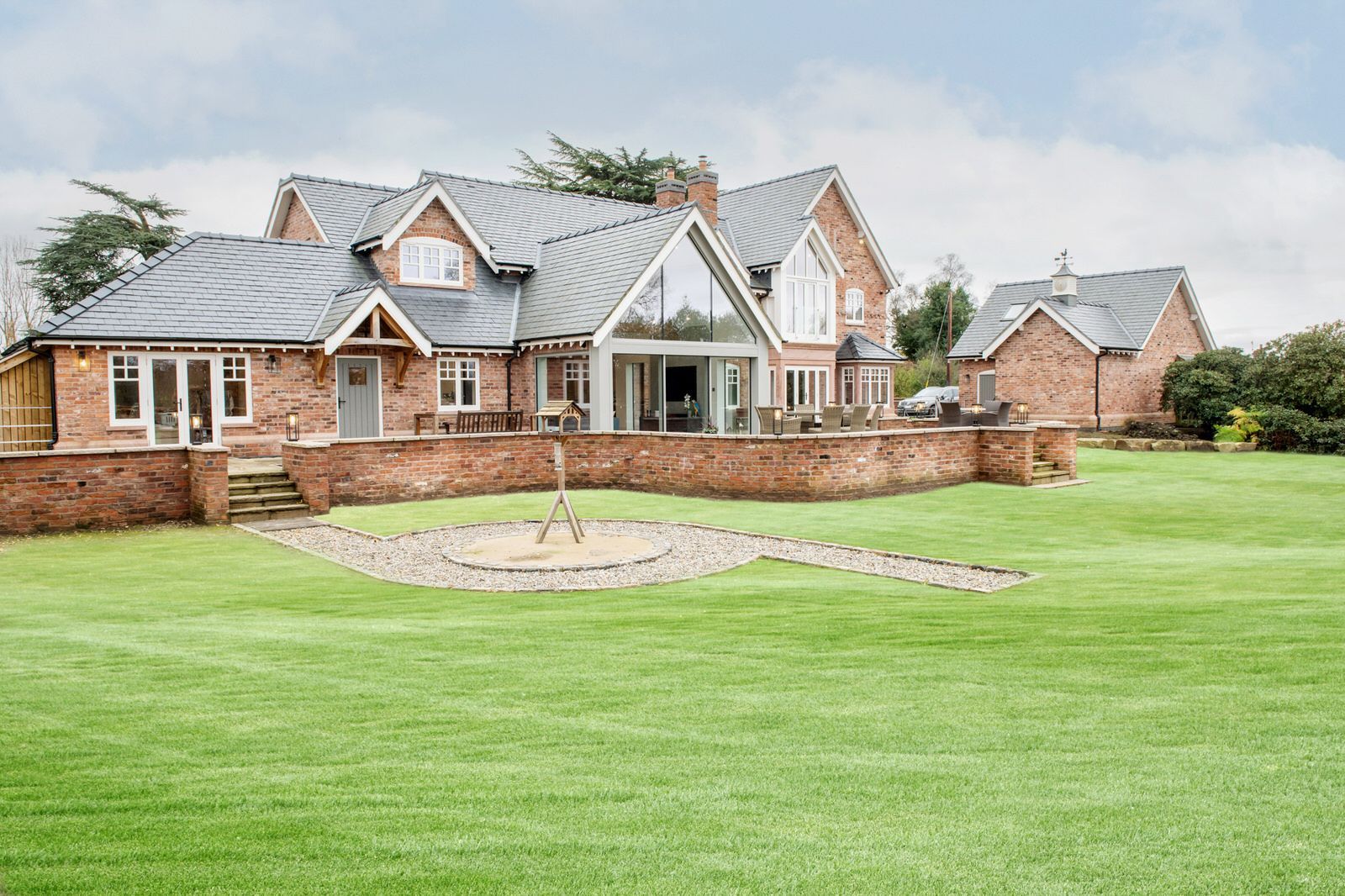 Exterior of new-build Cheshire residence with landscaped lawn and modern design by Rawlinson Construction