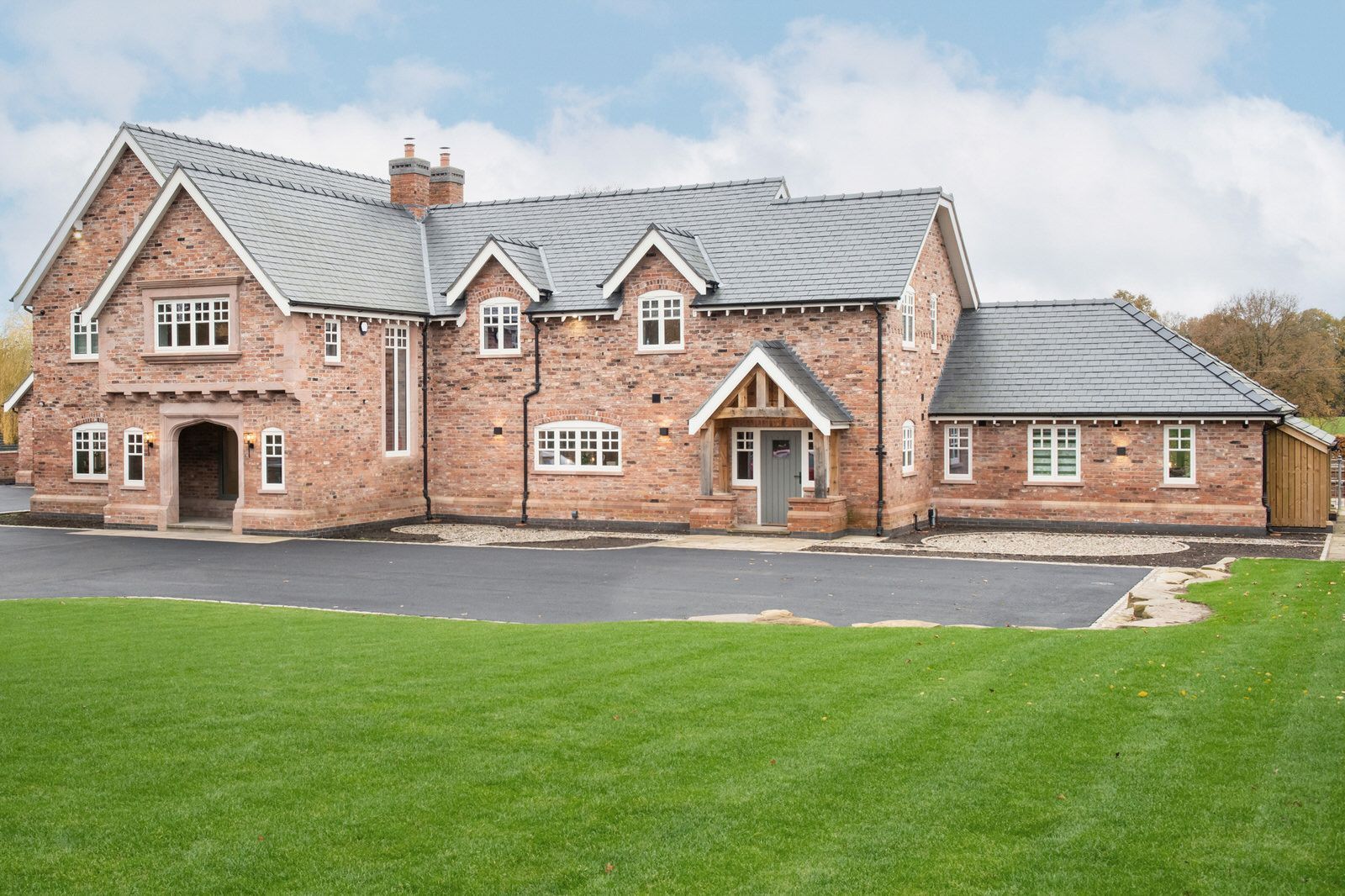 Exterior view of new build Cheshire home with landscaped lawns by Rawlinson Construction