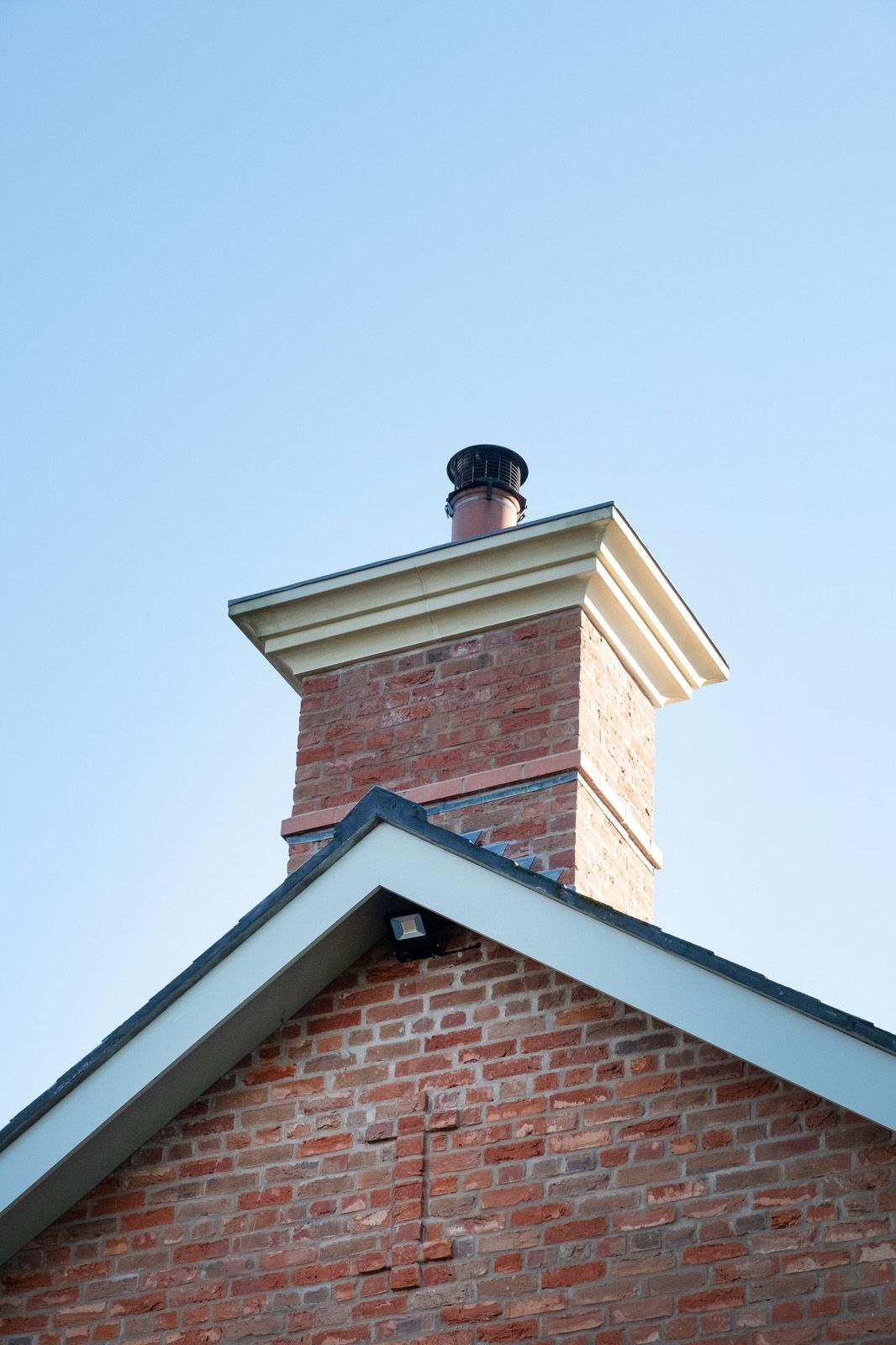 Brick chimney with traditional detailing on new Georgian-style farmhouse in Cheshire