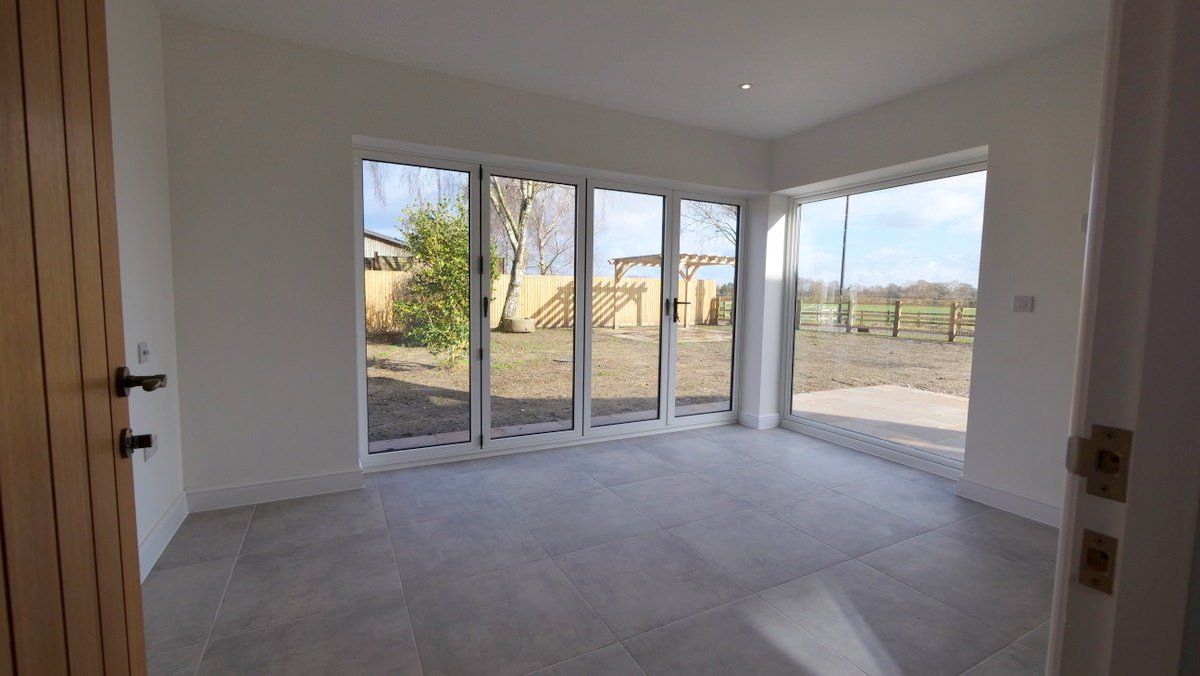 Glazed doors opening onto landscaped garden in new build timber-frame property
