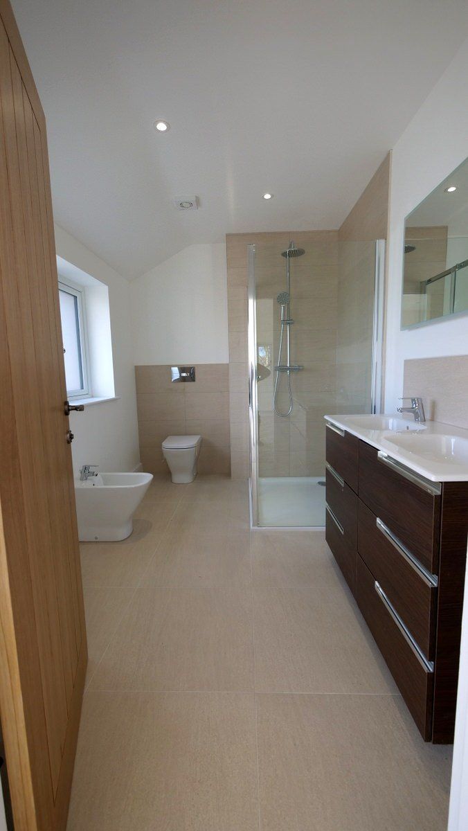 Bright contemporary bathroom featuring walk-in shower and stone-effect tiling in new build Cheshire home