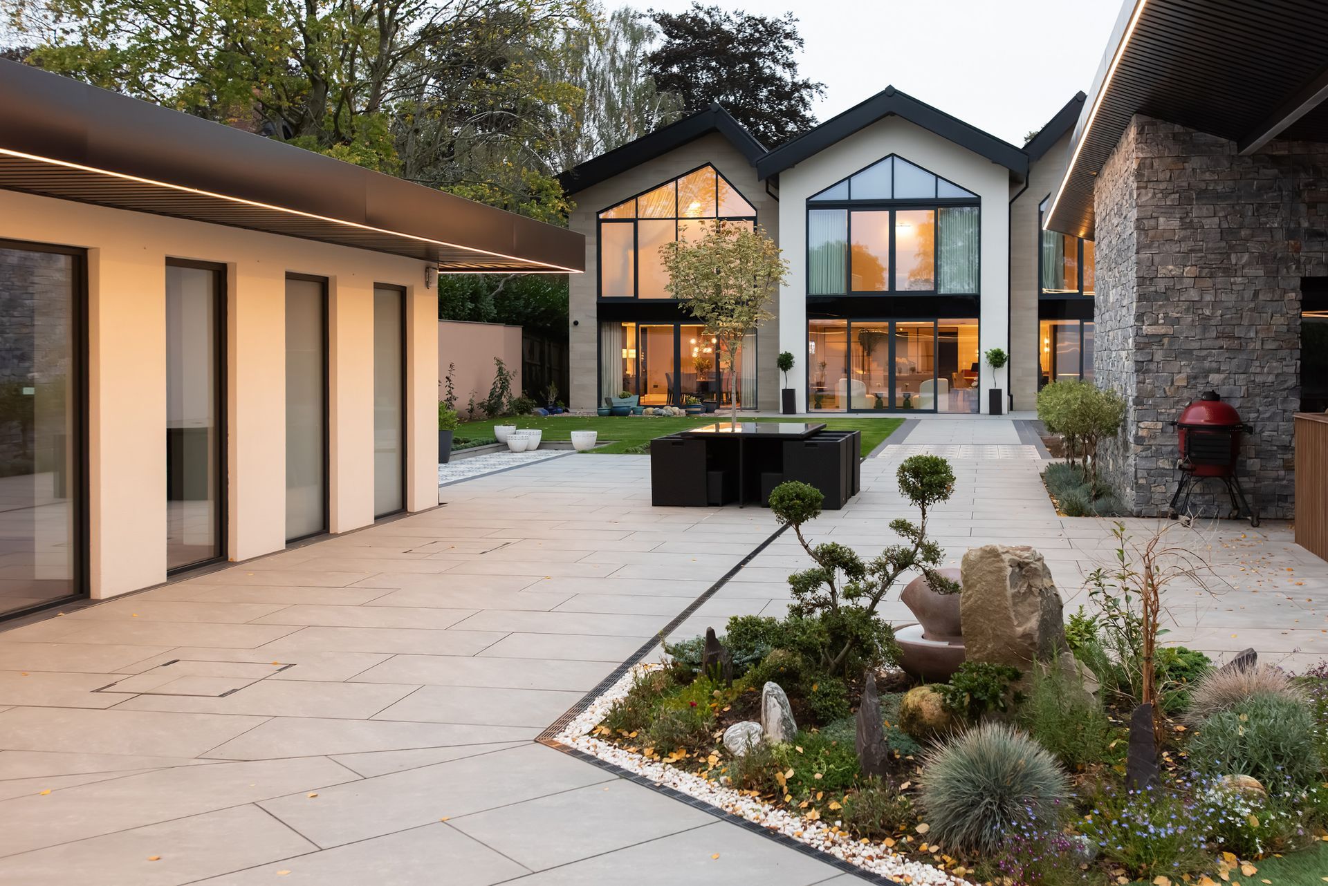 Outdoor space featuring landscaped lawns and rear view of luxury home built by Rawlinson Construction