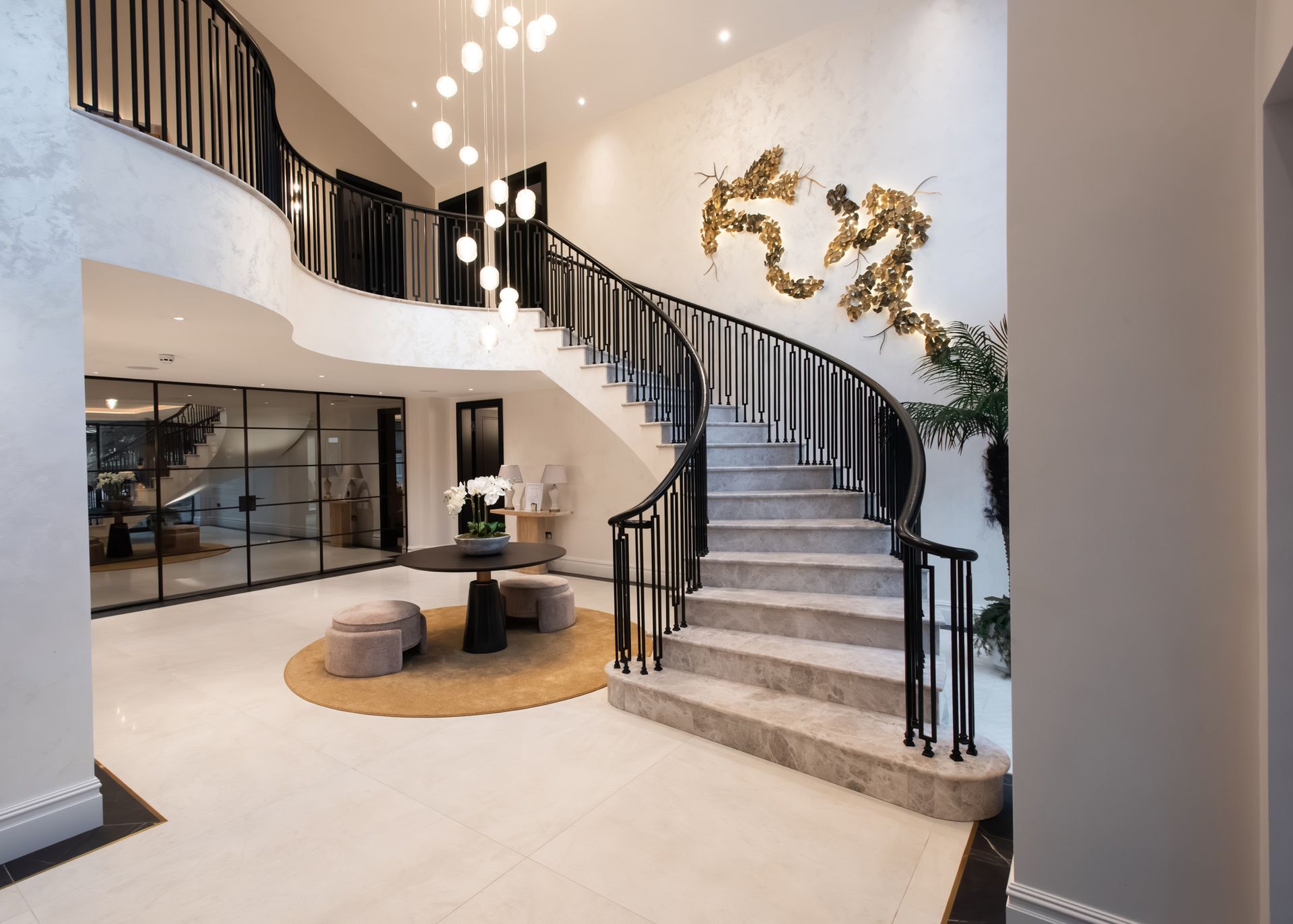 Open-plan staircase with sleek handrails and contemporary design in luxury Sandbach home completed by Rawlinson Construction
