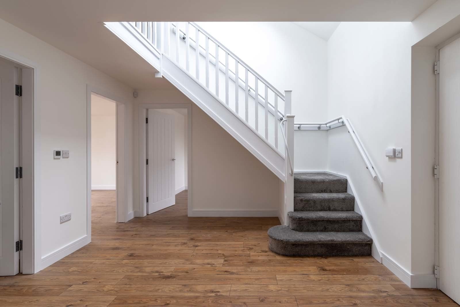 Spacious hall with contemporary finishes and natural light in dormer bungalow by Rawlinson Construction