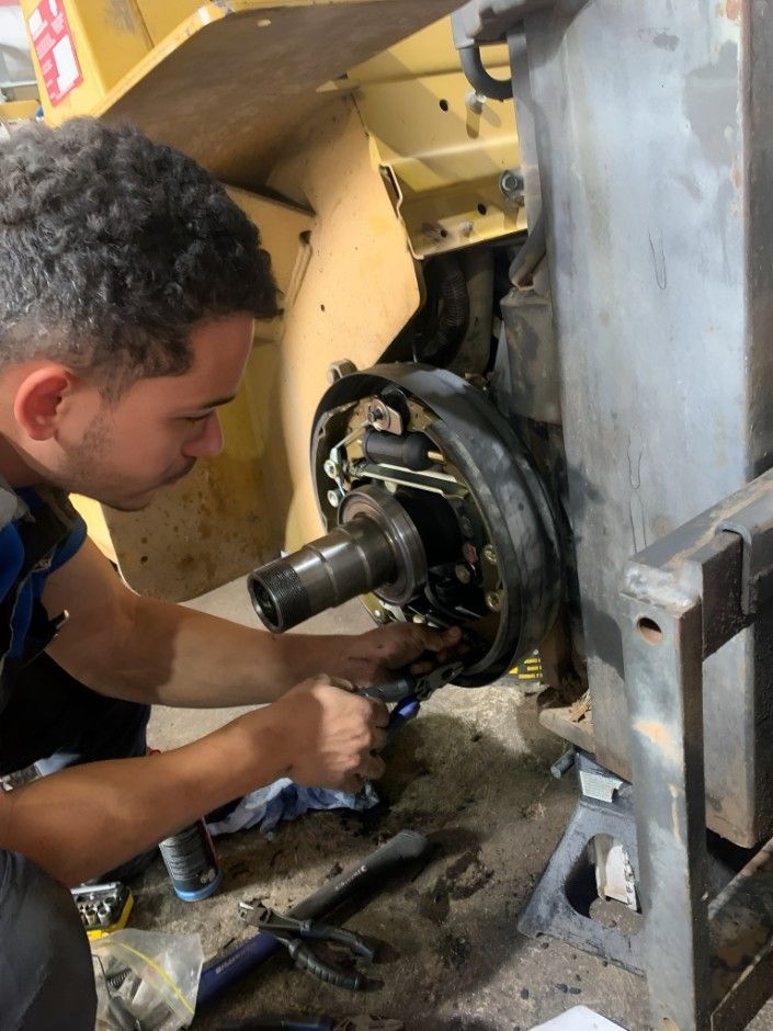 A Man Is Working On A Machine In A Garage — Central Diesel Services In Alice Springs, NT