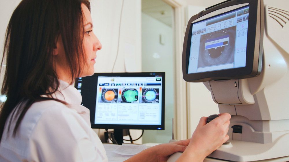 A Woman Is Sitting In Front Of A Computer Monitor — Eye Supply In Mareeba, QLD