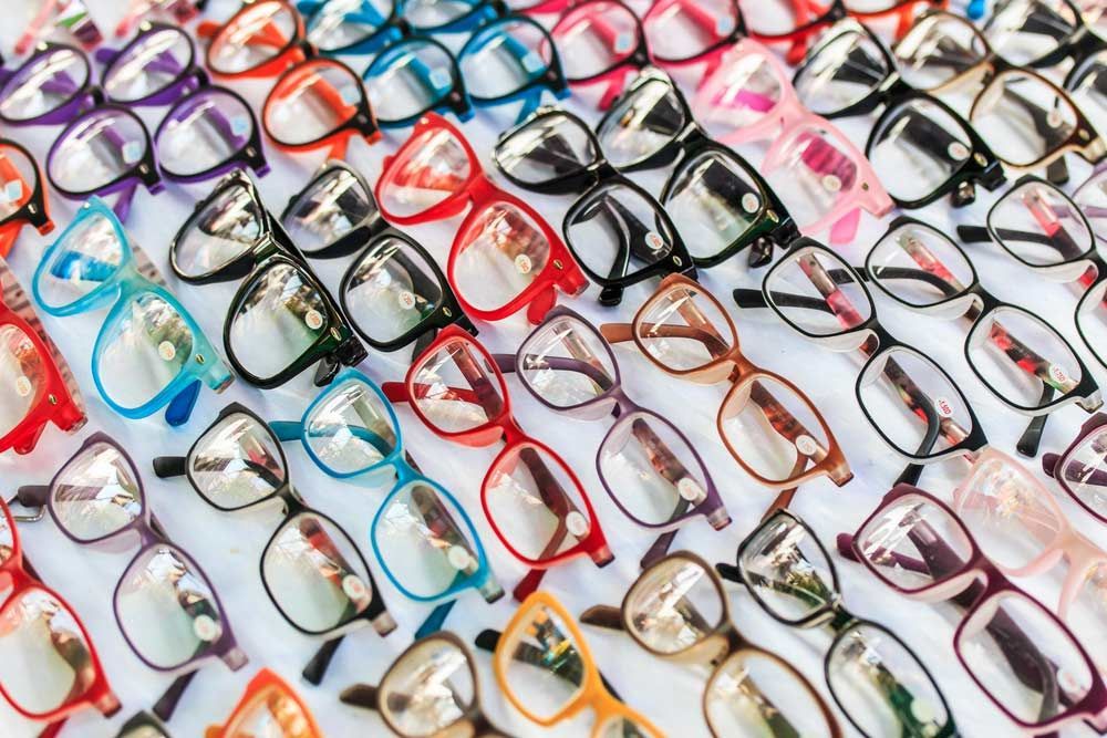 A Bunch Of Different Colored Glasses Are Lined Up On A Table — Eye Supply In Mareeba, QLD