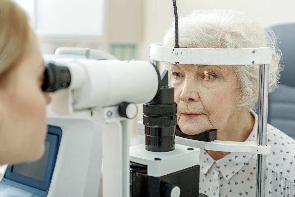 An Elderly Woman Is Getting Her Eyes Examined By An Ophthalmologist — Eye Supply In Mareeba, QLD