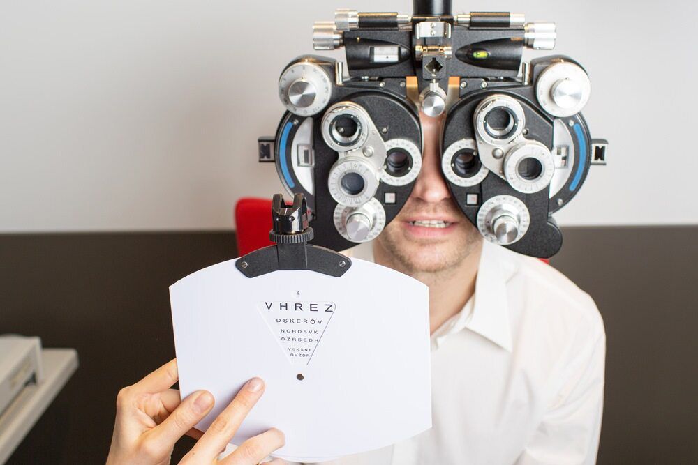 A Man Is Getting His Eyes Checked By An Ophthalmologist — Eye Supply In Mareeba, QLD