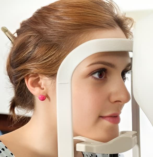 A Woman Wearing Pink Earrings Is Getting Her Eyes Examined — Eye Supply In Mareeba, QLD