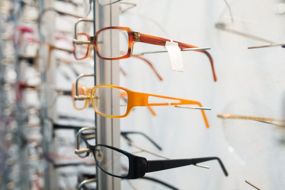 A Row Of Glasses Hanging On A Rack In An Optical Store — Eye Supply In Mareeba, QLD