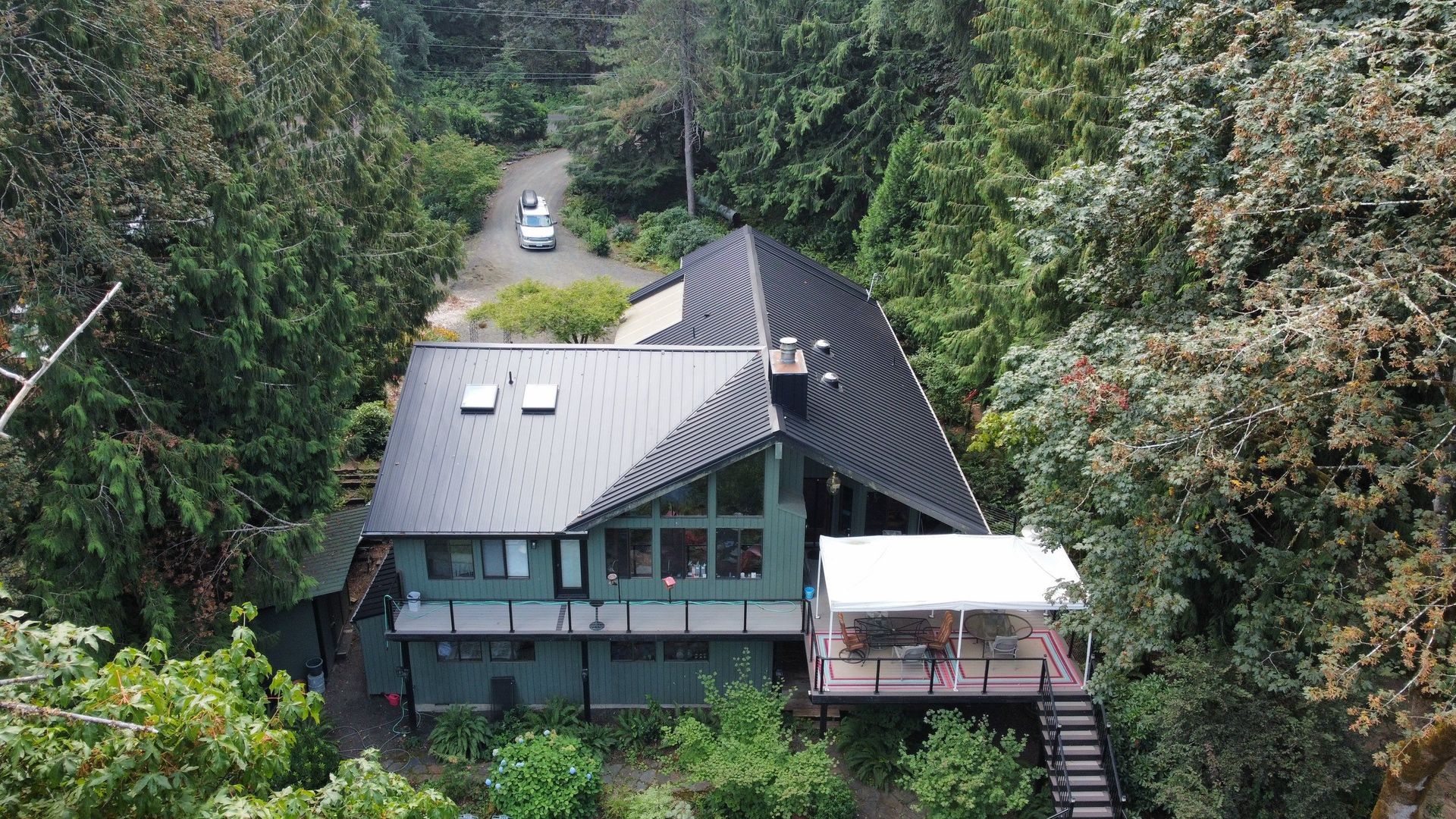 An aerial view of a house in the middle of a forest