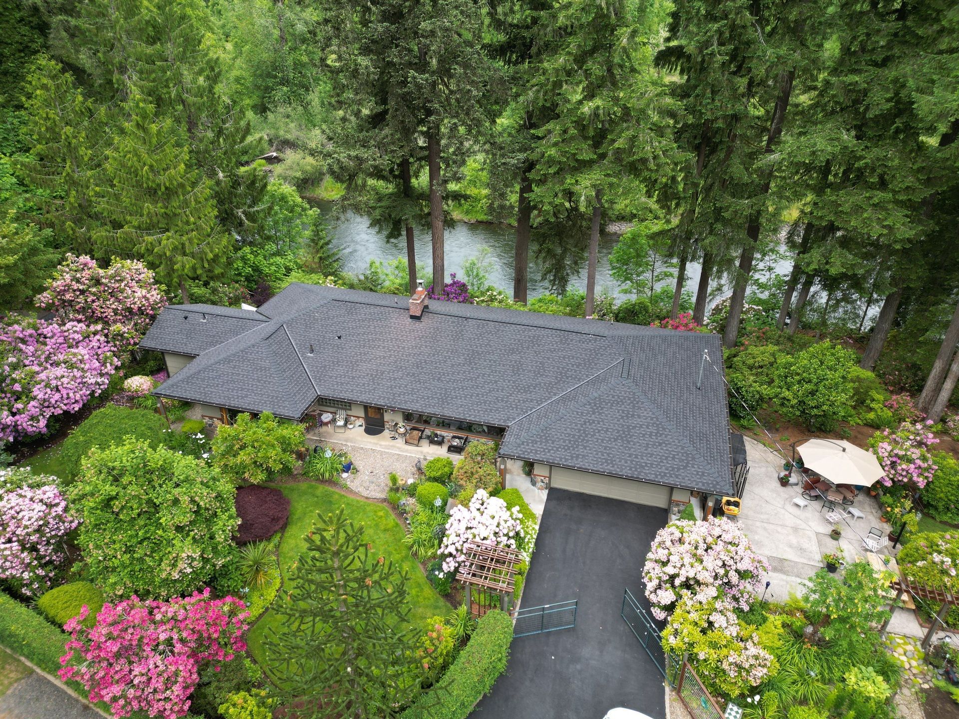 An aerial view of a house surrounded by trees and flowers.