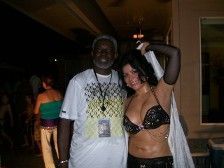 Man and woman in costume smiling for photo at event; outdoor setting.