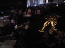 Champagne flutes projected on a dark surface, flowers and table settings. Wedding celebration.