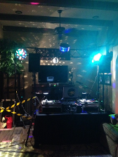 DJ setup with lights and sound equipment, indoor party scene.