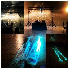 Party setup with DJ equipment, lighting effects, and projections of champagne glasses on the floor.
