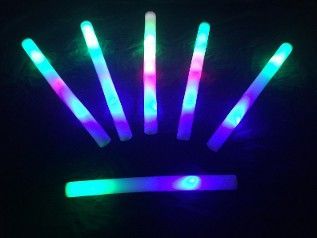 Glowing multicolored light sticks arranged in a fan shape against a dark background.