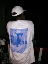 Person wearing a white t-shirt with blue text and logo that reads 