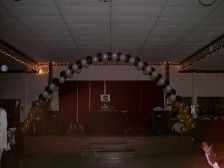 Balloon arch, black and white balloons, over a stage.