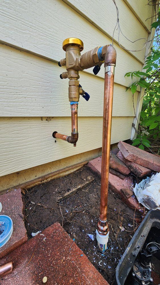 A copper pipe is being installed on the side of a house.