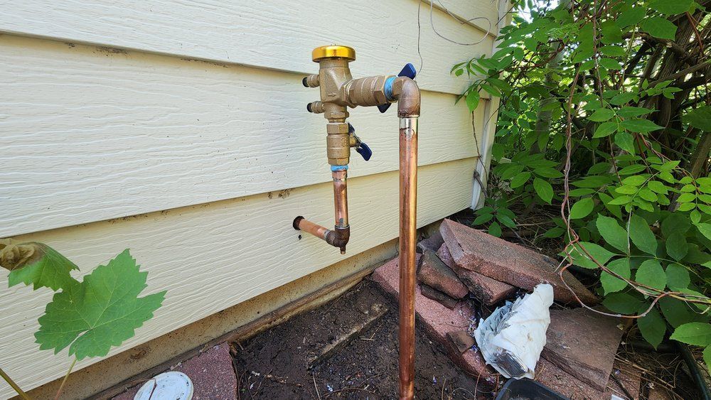 A copper pipe is attached to the side of a house.