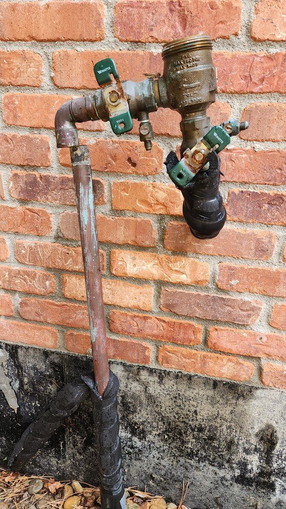 A water faucet is attached to a brick wall.