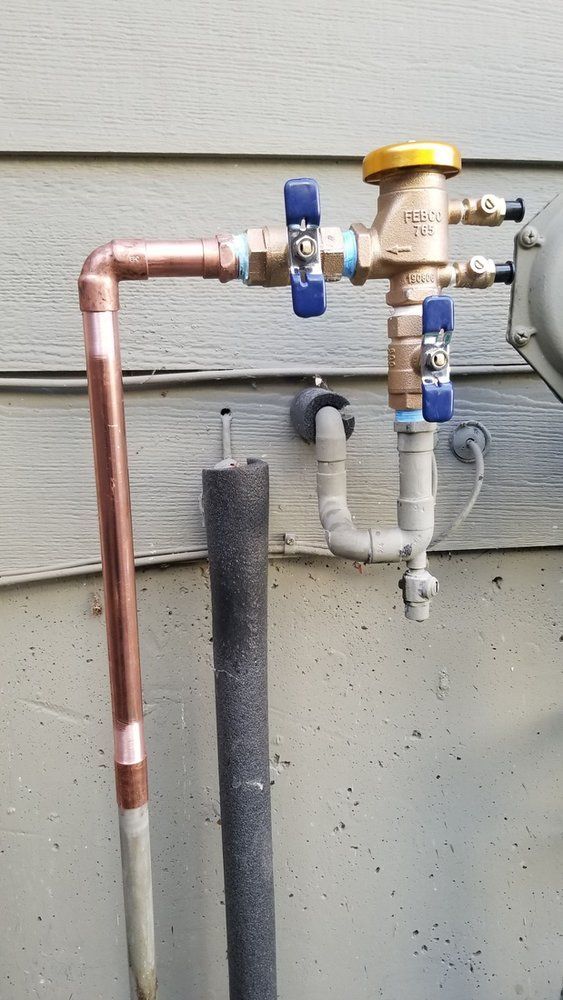 A close up of a copper pipe with a valve attached to it.