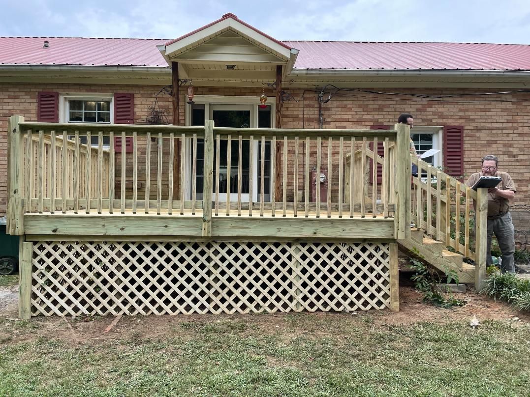 Front porch deck with stairs on a brick house; a person stands at the right side.
