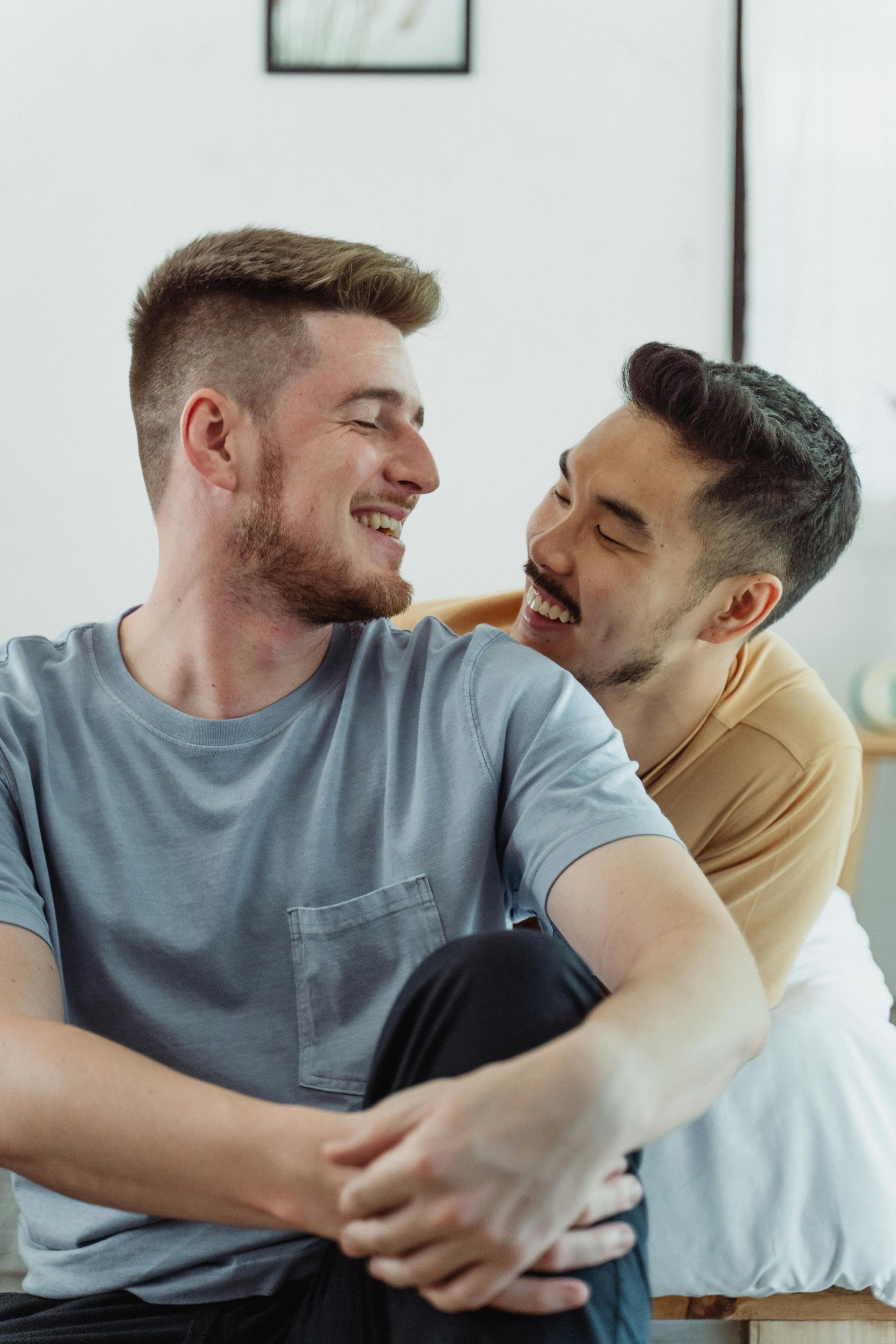 Deux personnes assises côte à côte, se souriant dans une pièce lumineuse