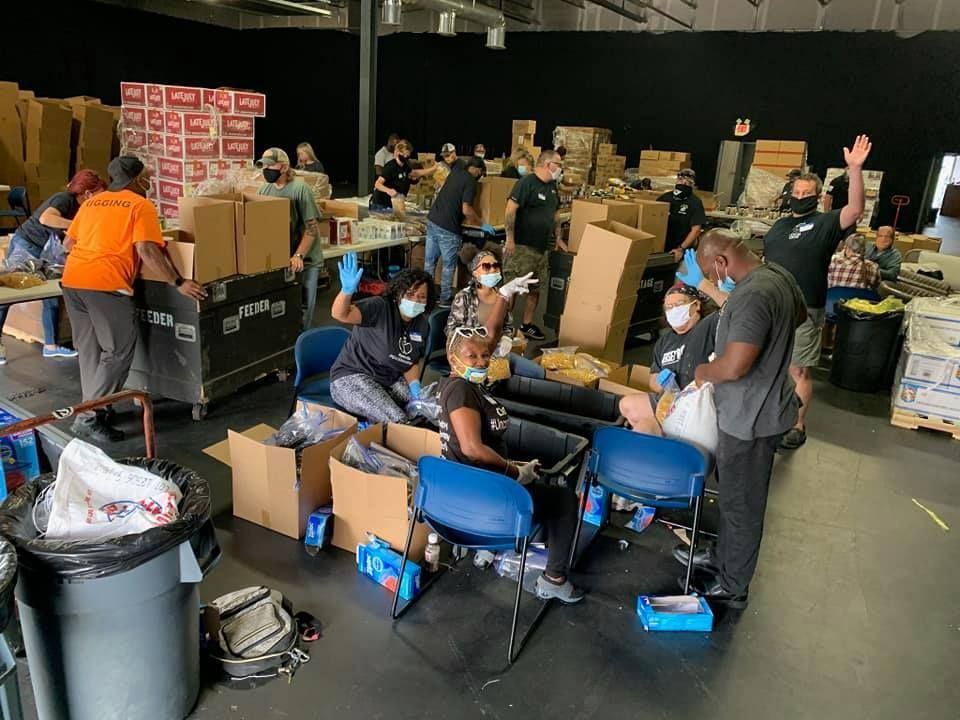 A group of people are working in a warehouse filled with boxes.