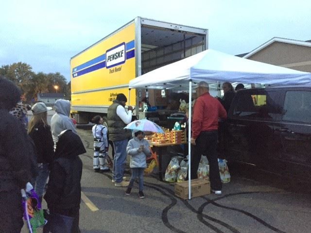 A group of people standing in front of a moving truck