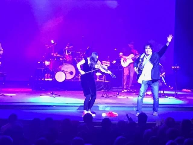 A man and a woman are singing on stage in front of a crowd