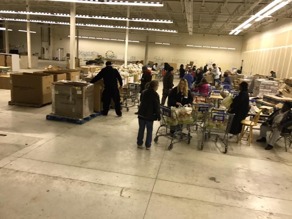 A group of people are standing in a large warehouse