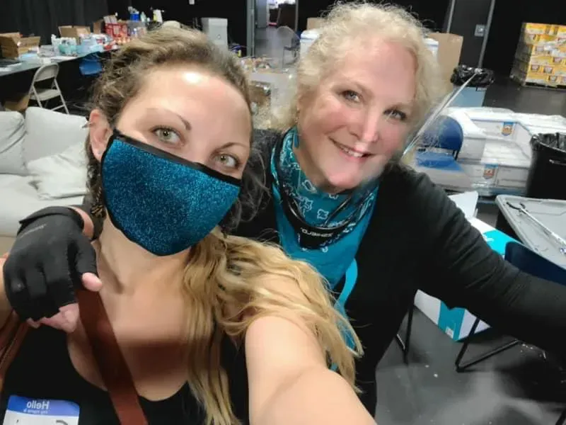 Two women wearing face masks are posing for a picture
