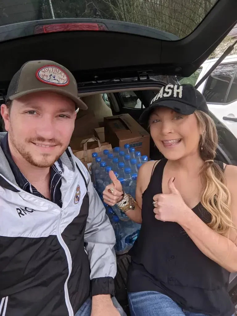 A man and a woman are sitting in the back of a car.