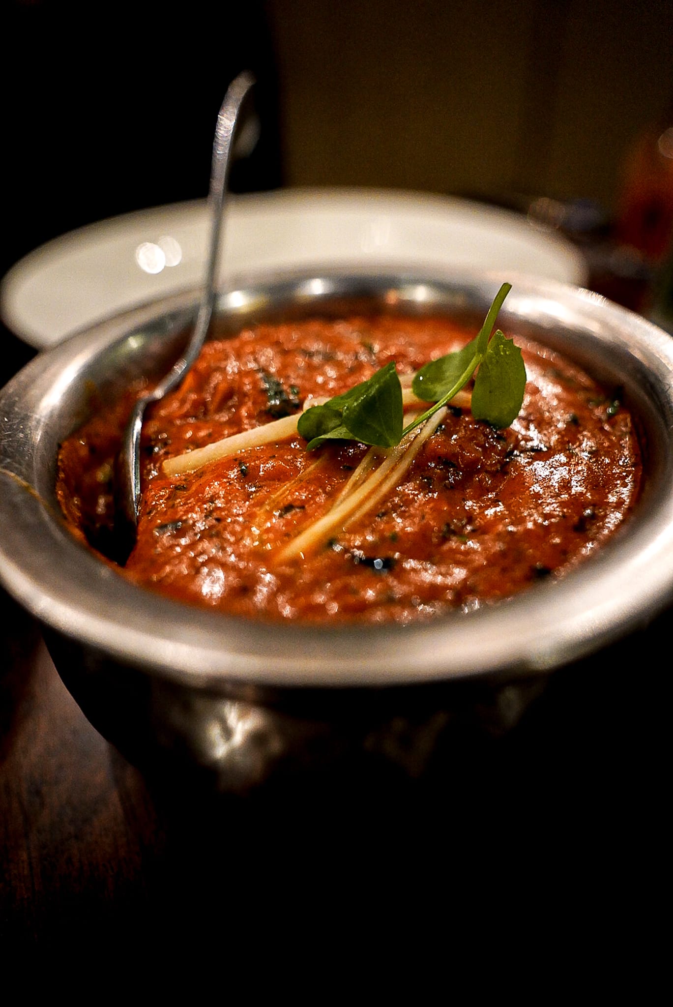 A bowl of food with a spoon in it on a table.