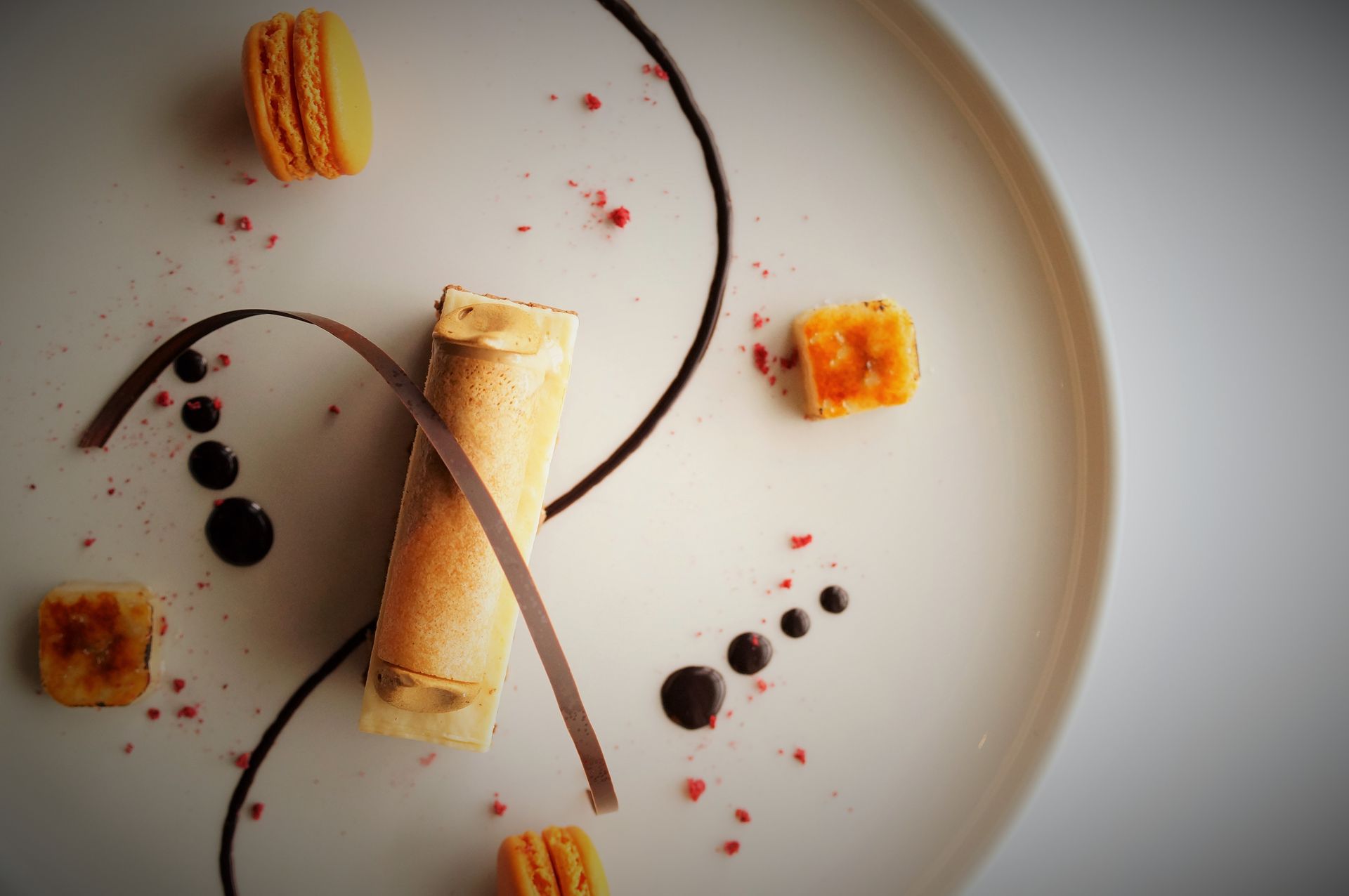 A white plate topped with a dessert and macarons