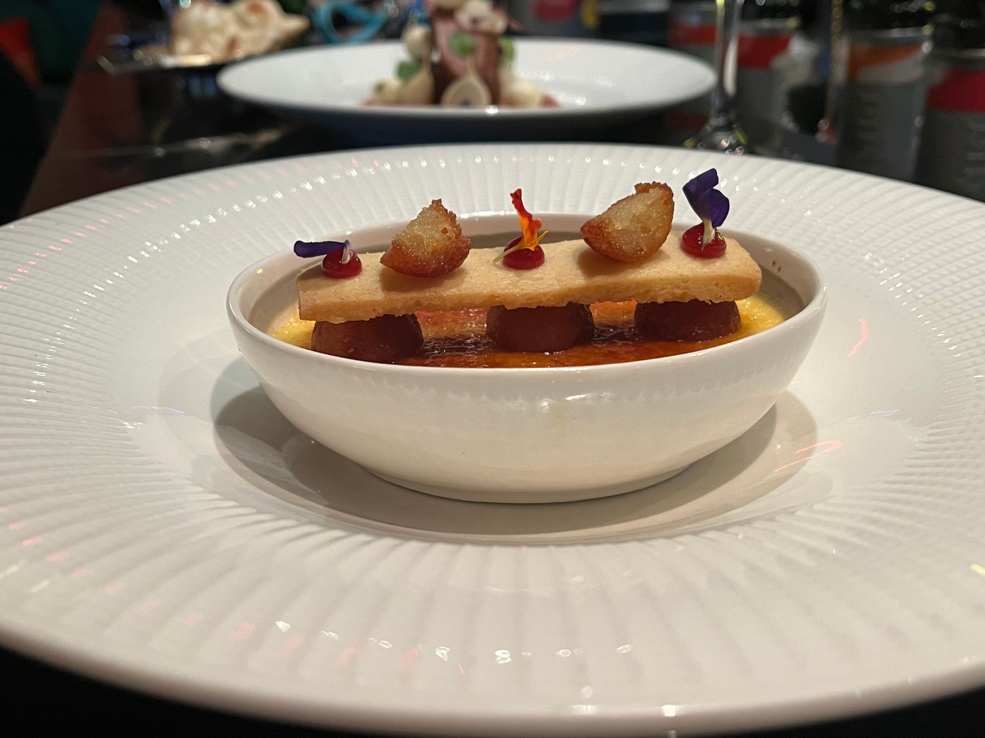 A white plate topped with a small bowl of food.