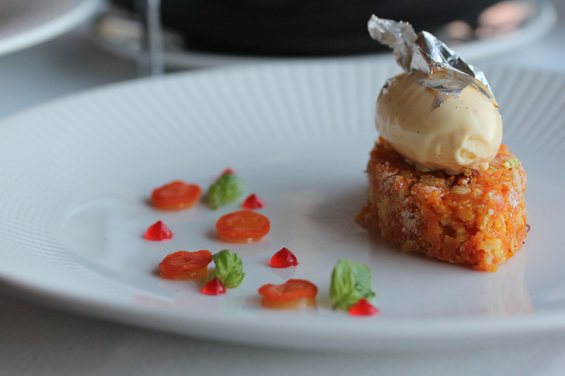 A white plate topped with a piece of food and a scoop of ice cream