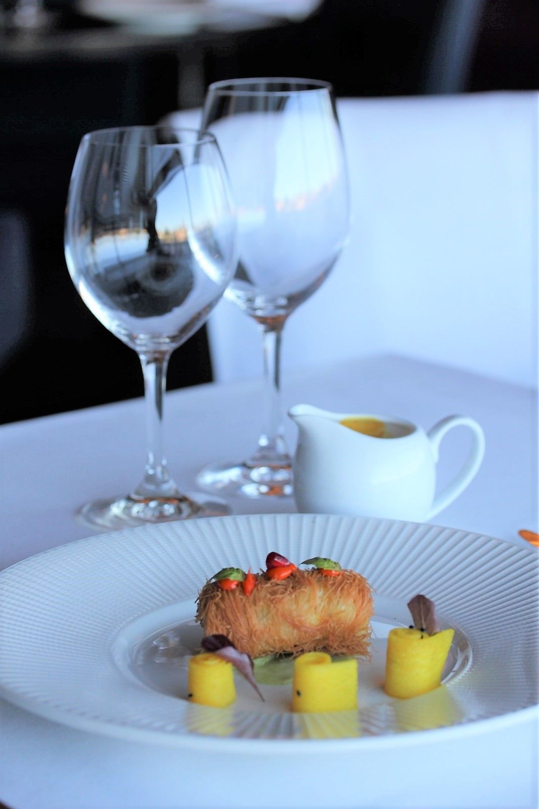 A plate of food and wine glasses on a table
