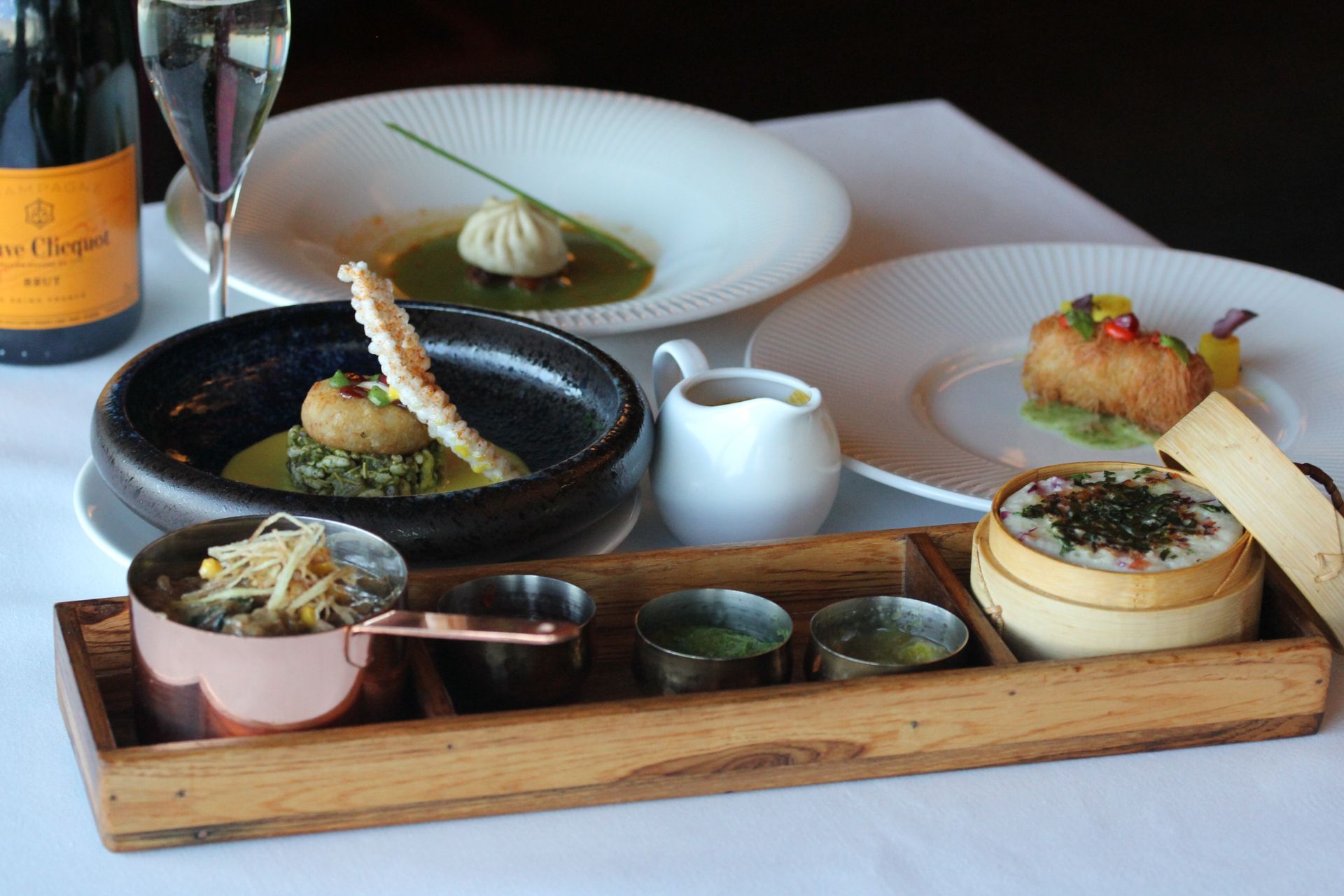 A table topped with plates of food and a bottle of champagne