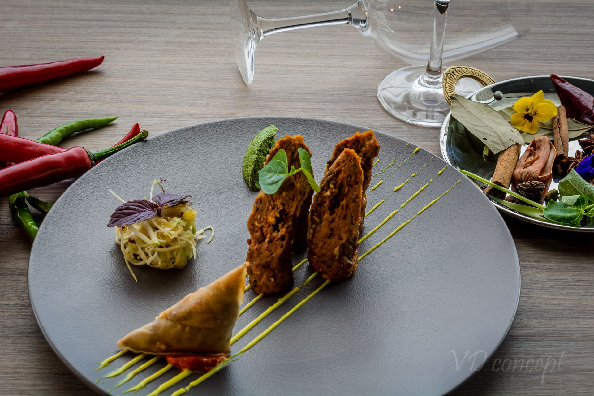 A plate of food is sitting on a table next to a glass of wine.