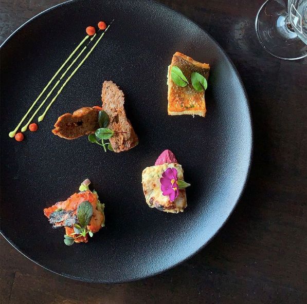 A black plate with a variety of food on it